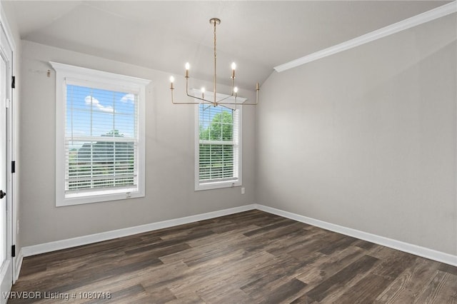 unfurnished dining area featuring dark wood-style flooring, ornamental molding, a notable chandelier, and baseboards