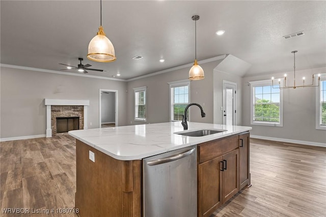 kitchen featuring a sink, stainless steel dishwasher, visible vents, and light wood-style floors