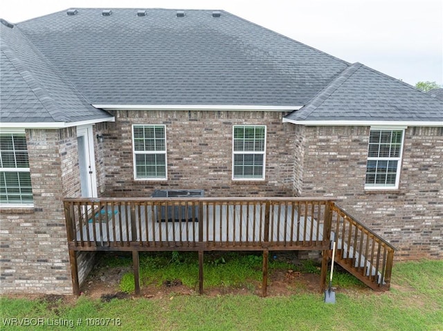 rear view of house featuring a deck, roof with shingles, and brick siding