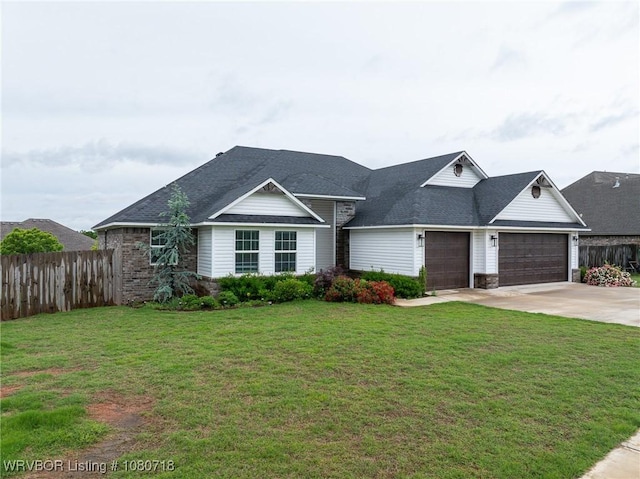 view of front of property with a front lawn, driveway, an attached garage, and fence
