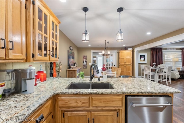 kitchen featuring light stone counters, decorative backsplash, sink, and hanging light fixtures