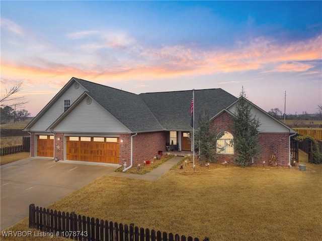 view of front of property with a garage and a lawn