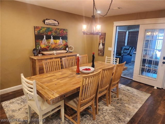 dining room featuring a notable chandelier and dark hardwood / wood-style floors