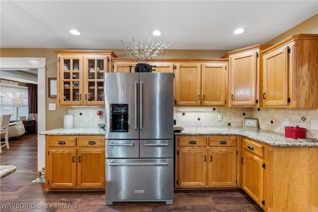 kitchen with tasteful backsplash, light stone countertops, dark wood-type flooring, and high end refrigerator