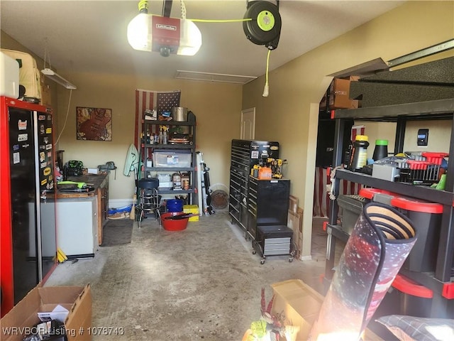 garage with a garage door opener and black refrigerator