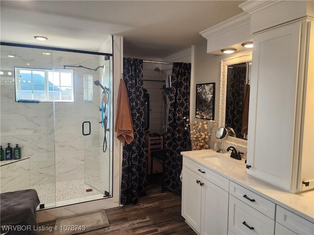 bathroom with hardwood / wood-style flooring, ornamental molding, vanity, and an enclosed shower