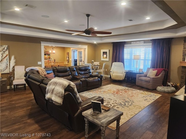 home theater with a raised ceiling, ceiling fan, and dark hardwood / wood-style flooring