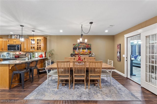 dining space with an inviting chandelier and dark hardwood / wood-style floors