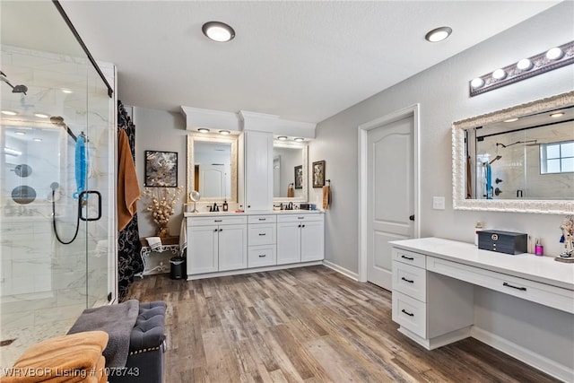 bathroom with vanity, an enclosed shower, and wood-type flooring