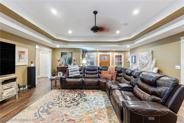 home theater room featuring hardwood / wood-style flooring and a tray ceiling