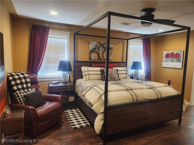 bedroom with dark hardwood / wood-style flooring and multiple windows