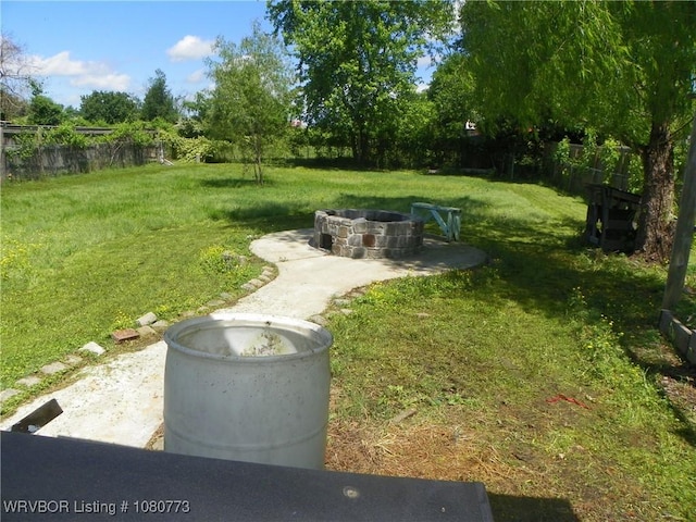 view of yard with fence and a fire pit