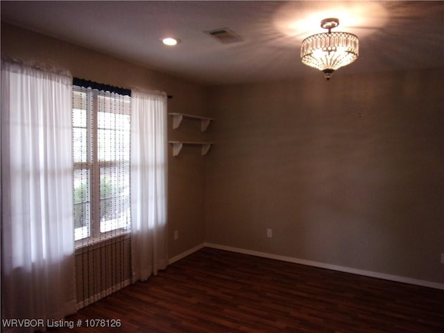 spare room with dark hardwood / wood-style flooring and radiator