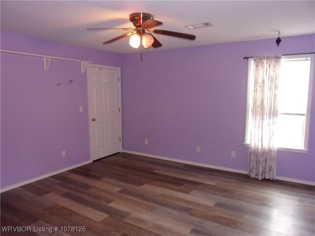 unfurnished room with dark wood-type flooring, ceiling fan, and plenty of natural light