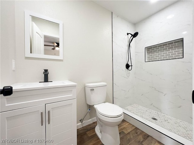 full bathroom with vanity, a shower stall, toilet, and wood finished floors