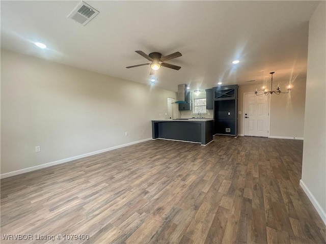 interior space with dark wood-style floors, visible vents, baseboards, and ceiling fan with notable chandelier