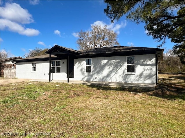 back of property with a patio area and a lawn