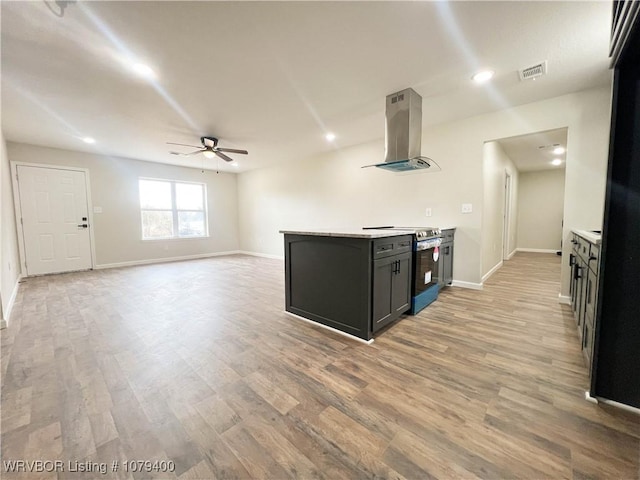 kitchen with visible vents, stainless steel electric range oven, extractor fan, light countertops, and light wood-type flooring