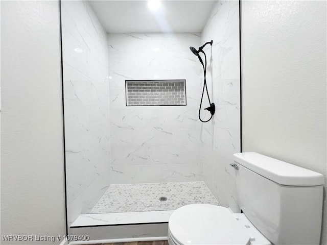 bathroom featuring a shower stall and toilet