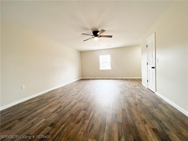 empty room featuring baseboards, dark wood finished floors, and a ceiling fan