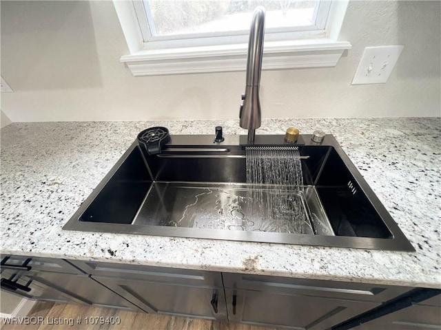 room details with a sink and light stone countertops