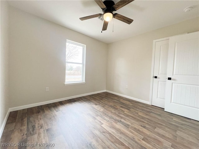 spare room featuring ceiling fan, baseboards, and wood finished floors