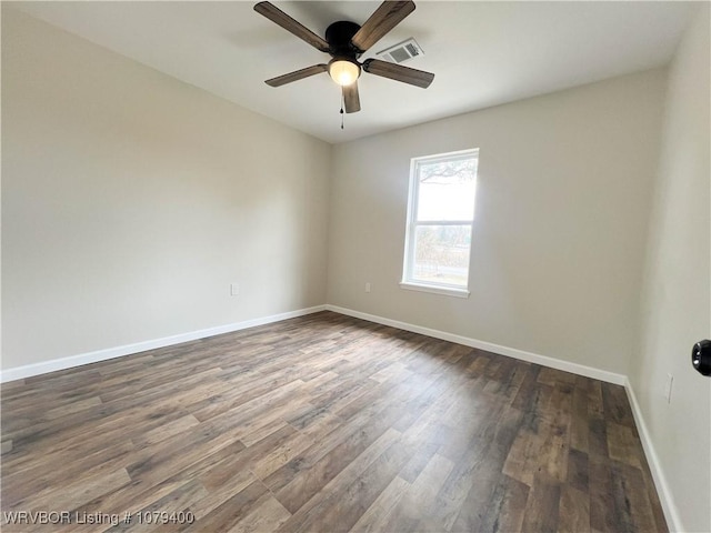 empty room featuring ceiling fan, dark wood-type flooring, visible vents, and baseboards