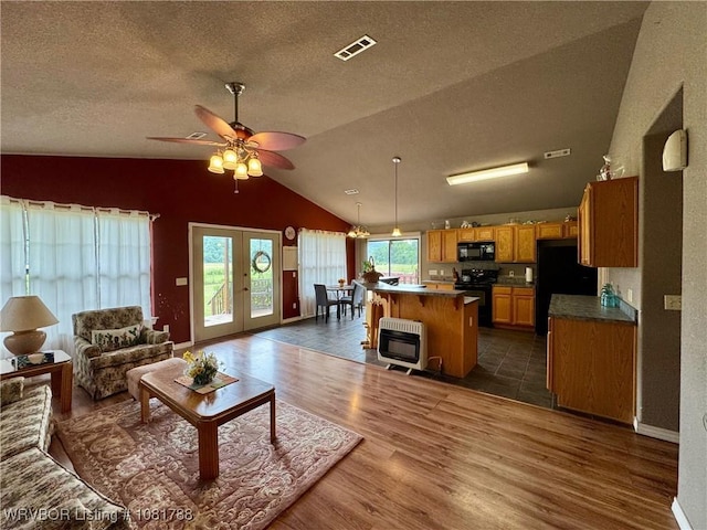 11739 282nd Hwy, Mountainburg, AR 72946 - living area with heating unit, vaulted ceiling, a textured ceiling, dark wood-type flooring, and ceiling fan
