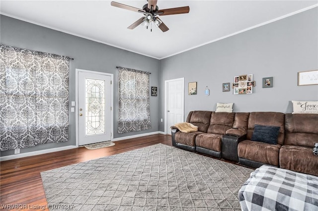 living room featuring wood finished floors, a ceiling fan, crown molding, and baseboards