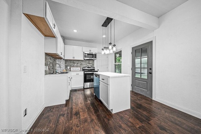 kitchen featuring dark wood-style flooring, a center island, stainless steel appliances, and a sink
