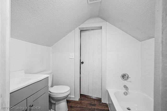 full bath featuring vaulted ceiling, wood finished floors, toilet, vanity, and a textured ceiling