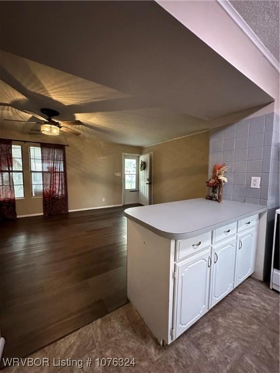 kitchen featuring kitchen peninsula, ceiling fan, and white cabinets