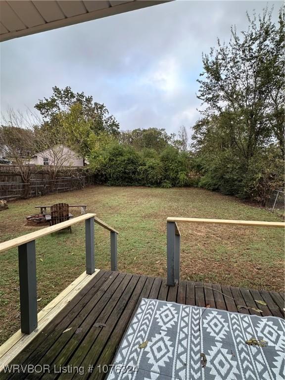 wooden deck featuring a lawn