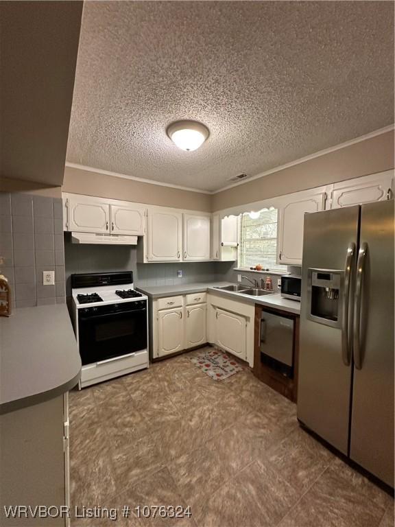 kitchen with white cabinets, appliances with stainless steel finishes, ornamental molding, and sink