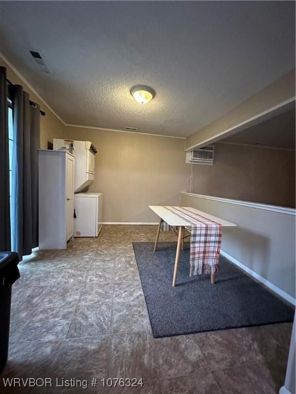 interior space featuring a textured ceiling and a wall mounted AC