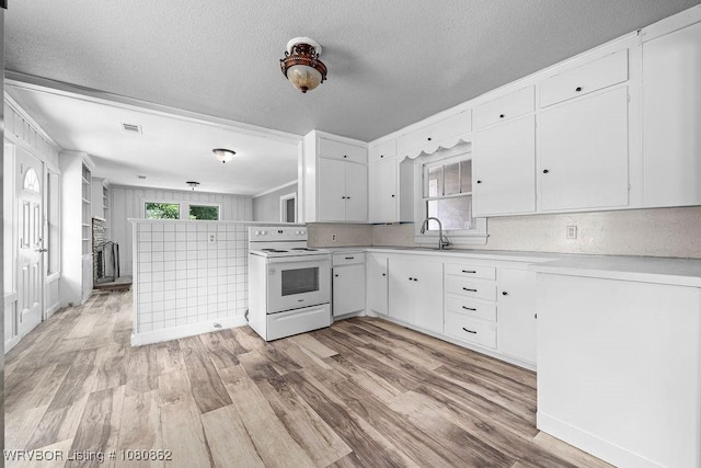 kitchen featuring electric range, light countertops, light wood-style flooring, white cabinets, and a textured ceiling