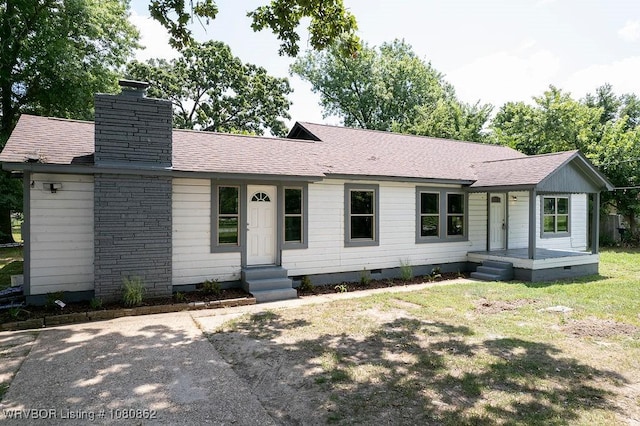 view of front of property featuring crawl space, a chimney, and a shingled roof