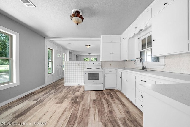 kitchen with white range with electric stovetop, white cabinets, a sink, light countertops, and a textured ceiling