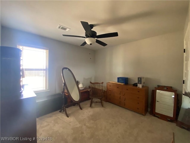 interior space with light colored carpet, visible vents, and ceiling fan