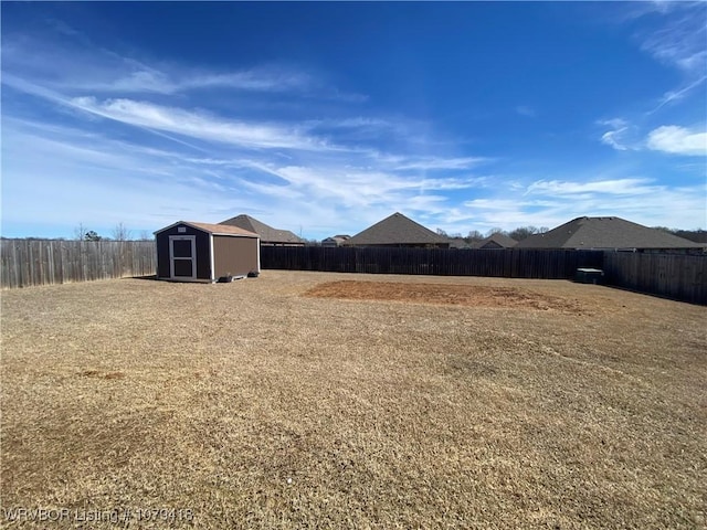 view of yard with an outbuilding, a shed, and a fenced backyard