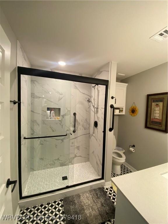 full bathroom with a marble finish shower, visible vents, toilet, vanity, and baseboards