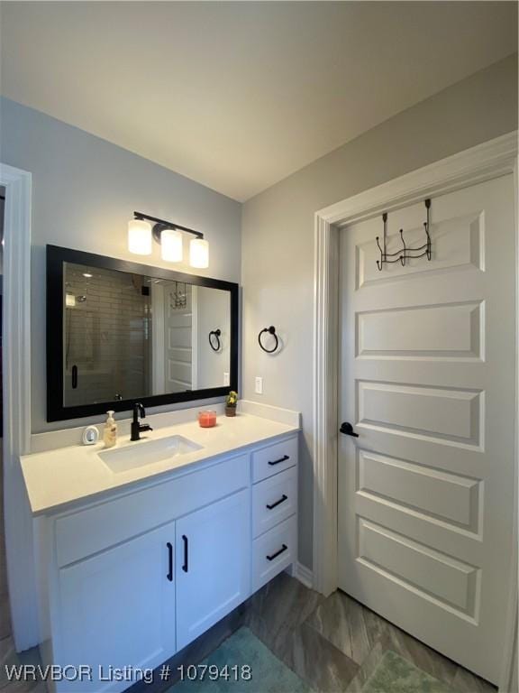 bathroom featuring marble finish floor, a shower stall, and vanity