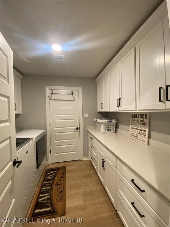 laundry room featuring cabinet space, wood tiled floor, visible vents, and washer and dryer