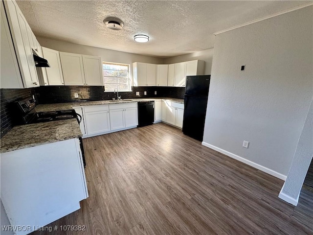 kitchen featuring a sink, baseboards, decorative backsplash, black appliances, and dark wood finished floors