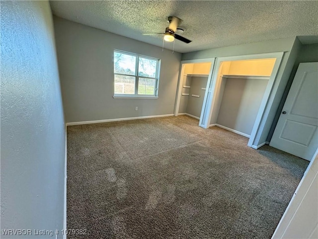 unfurnished bedroom with carpet floors, multiple closets, ceiling fan, a textured ceiling, and baseboards