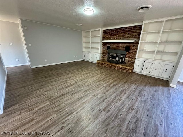 unfurnished living room featuring dark wood-style floors, baseboards, built in features, and a textured ceiling