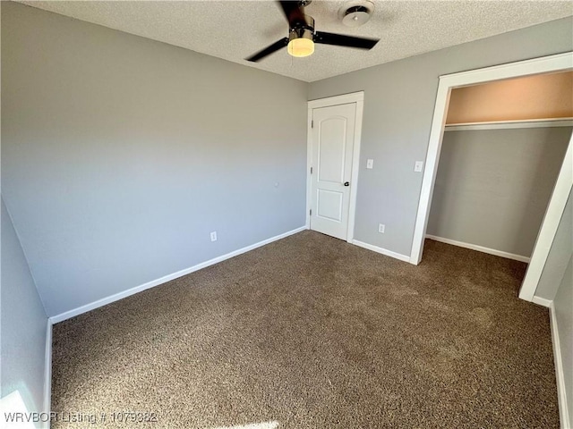 unfurnished bedroom featuring dark colored carpet, a closet, a ceiling fan, a textured ceiling, and baseboards