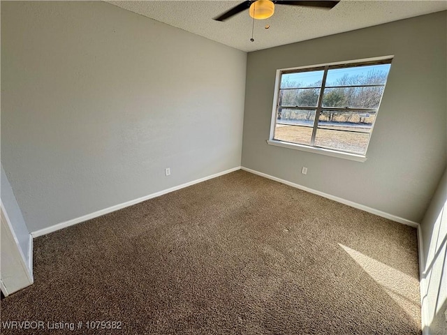 empty room with a ceiling fan, carpet, baseboards, and a textured ceiling