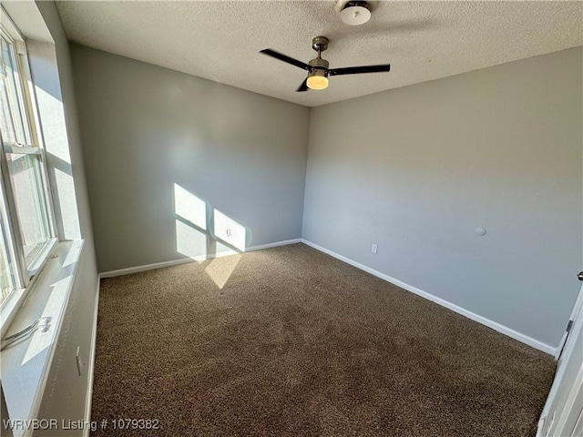 carpeted empty room featuring ceiling fan, a textured ceiling, and baseboards