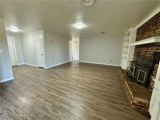 unfurnished living room with a textured ceiling, wood finished floors, visible vents, and baseboards